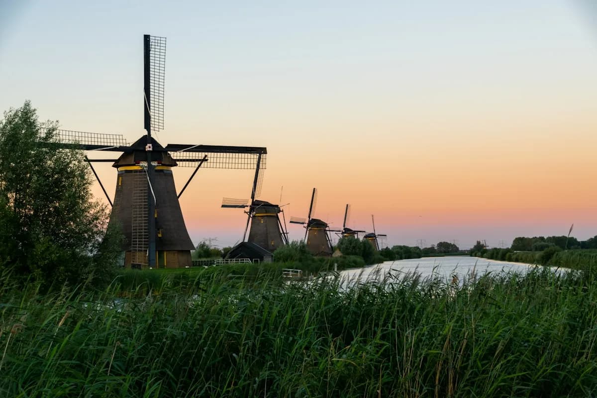 Kinderdijk windmolens bij zonsondergang langs een Nederlands waterkanaal